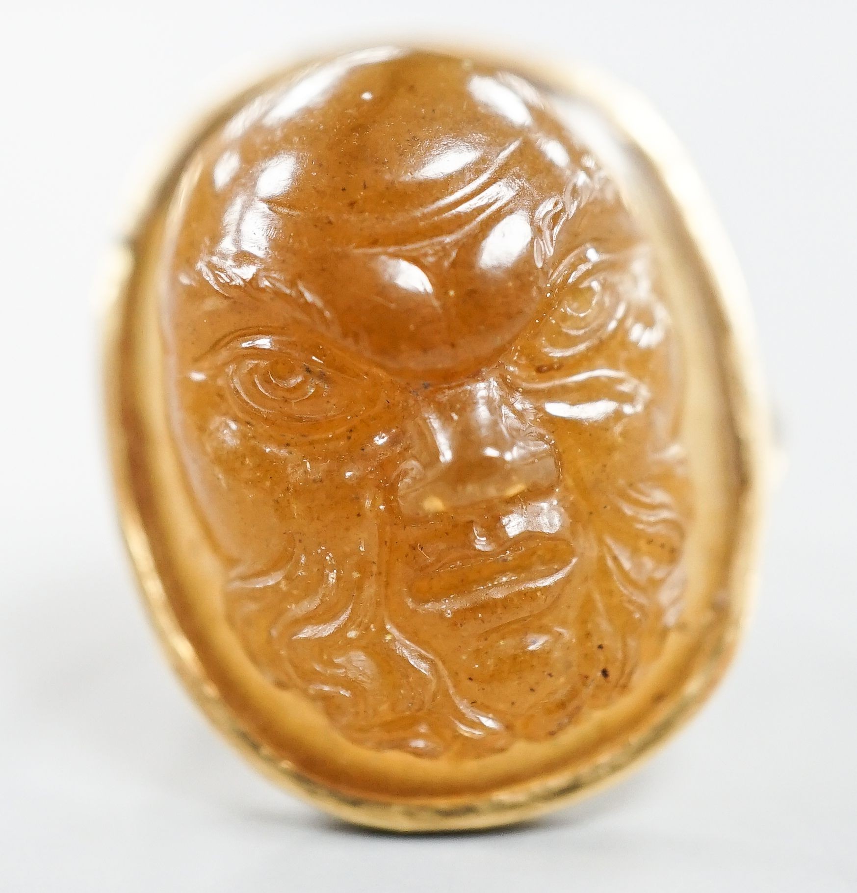 A yellow metal and cabochon brown chalcedony, carved with the face of a gentleman, size K, gross weight 7.3 grams.